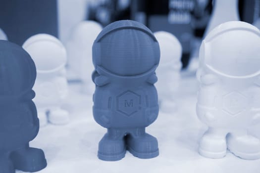 Art object model of astronaut printed on 3D printer. Toy created by 3D printing from molten plastic. Example of creating prototype by 3D printer. Concept 3D printing. 3D printing innovation technology