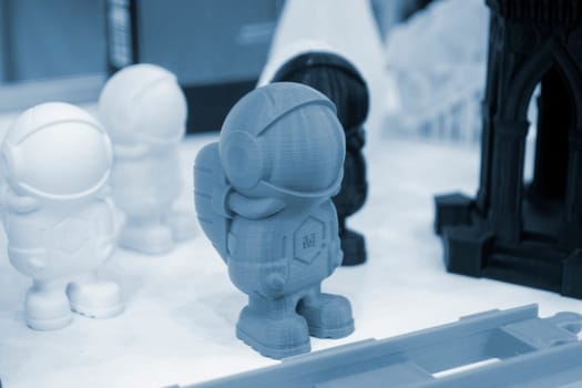 Art object model of astronaut printed on 3D printer. Toy created by 3D printing from molten plastic. Example of creating prototype by 3D printer. Concept 3D printing. 3D printing innovation technology