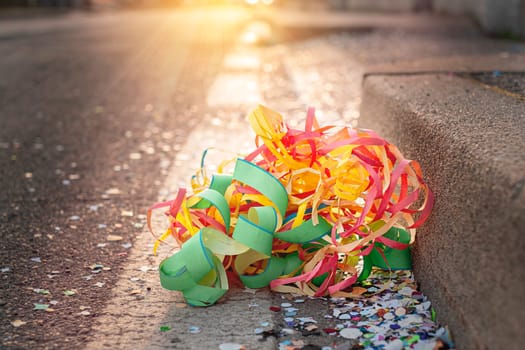 Close up colorful confetti and streamers at the street after Carnival parade