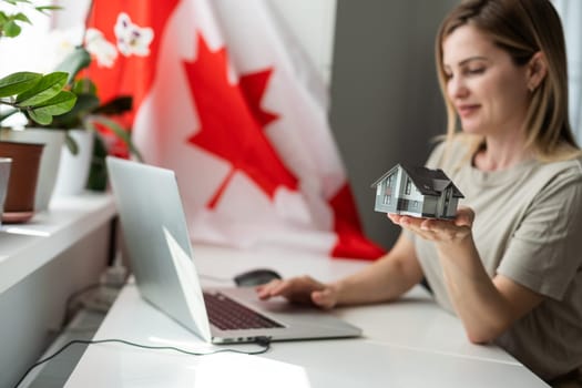 cropped view of female student with canadian flag presenting laptop . High quality photo