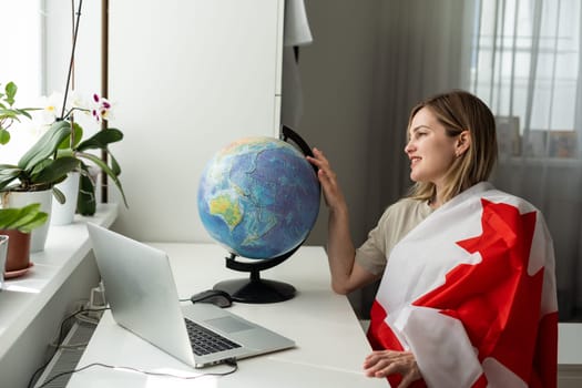 cropped view of female student with canadian flag presenting laptop . High quality photo