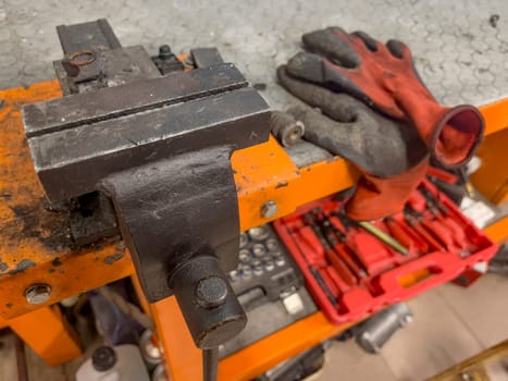 A pair of work gloves and a pair of wrenches are neatly placed on a work bench, ready to be used for repairs or maintenance tasks.