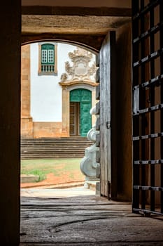 Facade of a baroque church seen from inside a historic prison from the time of the empire in the city of Mariana in Minas Gerais
