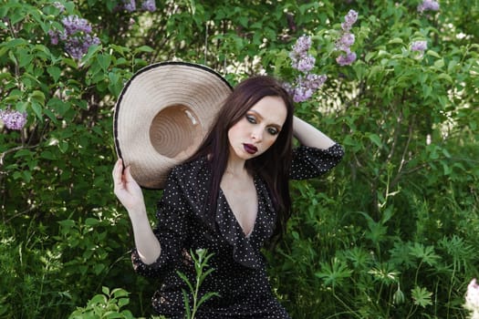 A fashionable girl with dark hair, a spring portrait in lilac tones in summer. Bright professional makeup