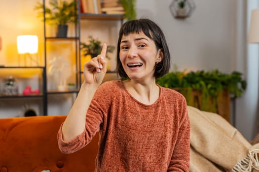 Eureka. Thoughtful clever inspired Hispanic woman make positive gesture raises finger came up with creative plan feels excited with good idea, inspiration motivation. Portrait of girl at home in room