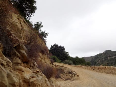 Curve in Dirt road leading upwards through hills of Santa Barbara, California.                               