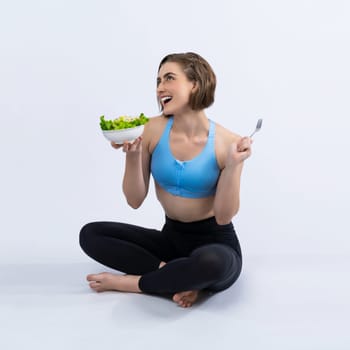 Full body length gaiety shot athletic and sporty young woman with healthy vegan food in standing posture on isolated background. Healthy active and body care by vegetarian lifestyle.