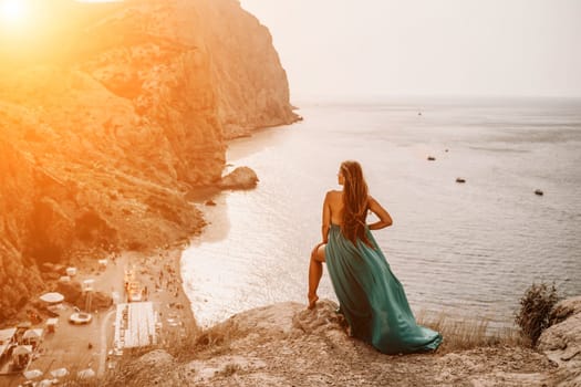 Woman sea trevel green dress. Side view a happy woman with long hair in a long mint dress posing on a beach with calm sea bokeh lights on sunny day. Girl on the nature on blue sky background