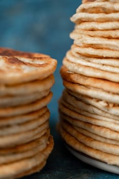 Flatbread lavash, chapati, naan, heap of tortilla on a blue background Homemade flatbread stacked