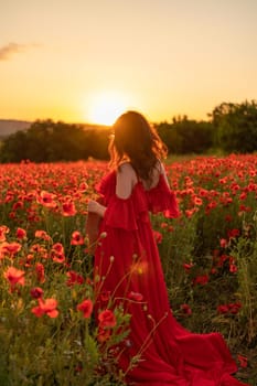 Woman poppy field red dress sunset. Happy woman in a long red dress in a beautiful large poppy field. Blond stands with her back posing on a large field of red poppies.