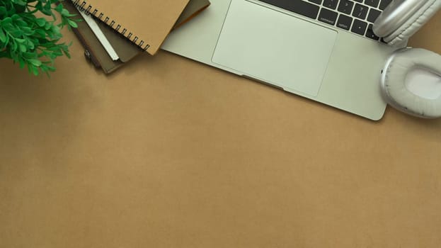 Simple workplace with laptop, cup of coffee, notepad and headphone. Top view with copy space.