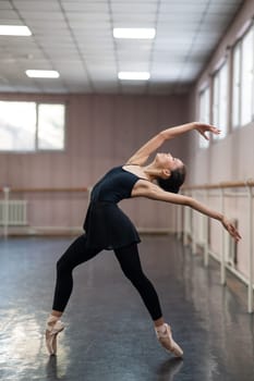 Asian woman dancing in ballet class. Bending in the back