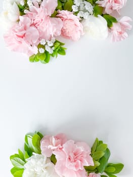 Border frame made of pink and white carnations flower on white background. Flat lay, top view. Flowers frame.