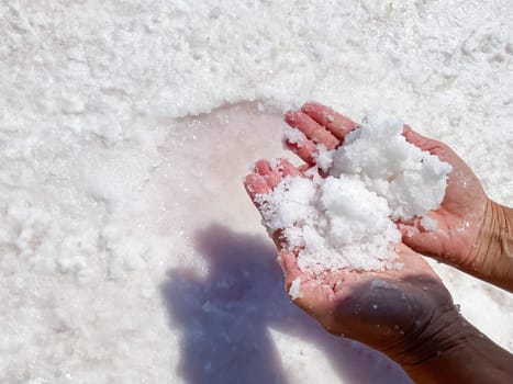 Womans hands with salt in her hands against the backdrop of salt lake. High quality photo