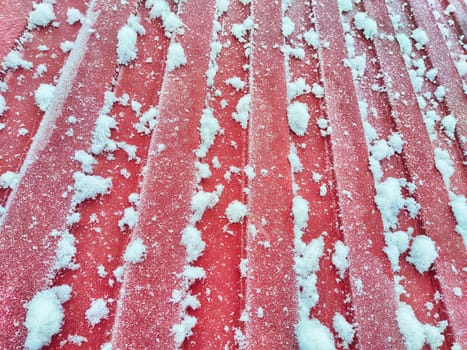 Fence made of galvanized corrugated board in the snow In the village after a snowfall. Abstract background, pattern, texture, place for text and copy space