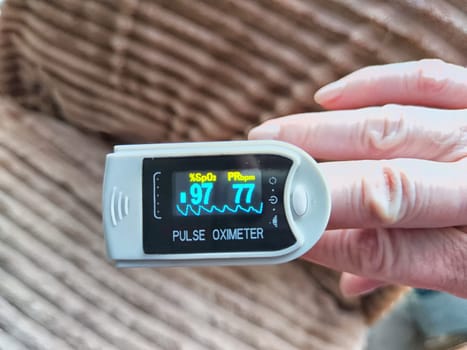 Close up of hand with a pulse oximeter on the finger.