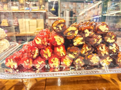 Various types or many colorful assortment of Turkish sweets for sale in shop food festival. Baklava and pastries are sold on trays on the counter. Ramadan, travel