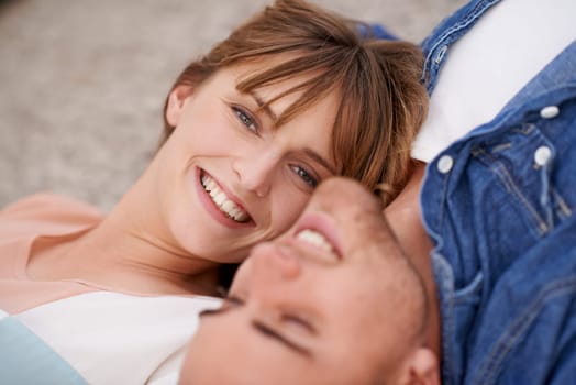 Portrait, couple and love with care while lying down for affection at home. Man, woman and relax in relationship with bonding and romance in a calm and peaceful house for leisure with smile on floor.