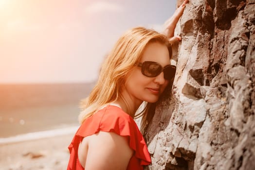 Young woman in red bikini on Beach. Blonde in sunglasses on pebble beach enjoying sun. Happy lady in one piece red swimsuit relaxing and sunbathing by turquoise sea ocean on hot summer day. Close up,