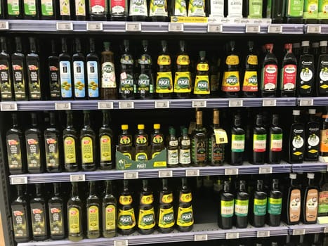 FRANCE, BORDEAUX, February, 2, 2024: Shelving for a large stock virgin olive oil bottles for sale at supermarket. High quality photo