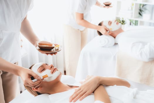 Serene ambiance of spa salon, couple indulges in rejuvenating with luxurious face cream massage with modern daylight. Facial skin treatment and beauty care concept. Quiescent
