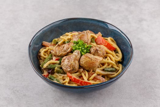 Wok with creamy curry on stone background studio shot