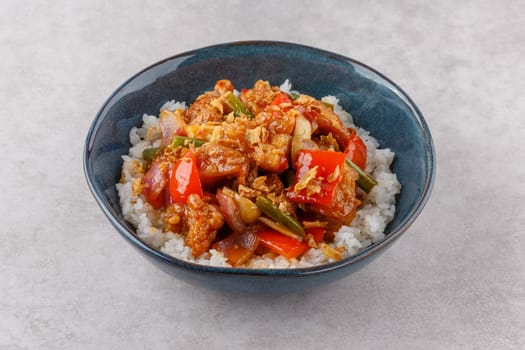 Chicken with rice in sweet and sour sauce on a stone background, studio shooting