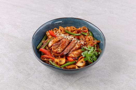 Wok with pork on a stone background studio shooting