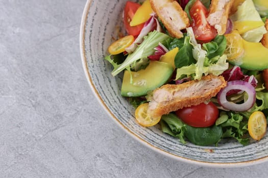 bowl with battered bacon, avocado and kumquat on stone background, studio food photography