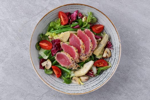 salad with carpaccio, artichoke and asparagus on a stone background, studio food photography
