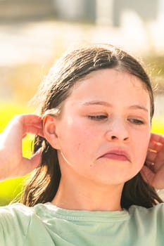 A joyful young girl gleefully gets soaked in refreshing water mist during a hot summer day.