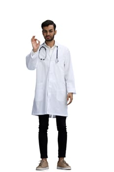 male doctor on a white background. full length shows ok sign.