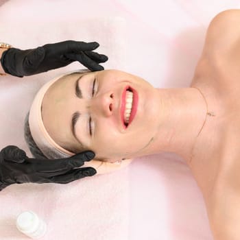 Ivano-Frankivsk, Ukraine May 17, 2023: Facial massage in a spa salon, a cosmetologist performs a relaxing procedure on a girl's face, anti-aging massage