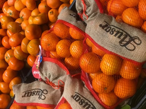 FRANCE, BORDEAUX, February, 2, 2024: Mandarin orange fruits for sale at the supermarket with one fruit peeled, Mandarin orange full of vitamin c, High quality photo
