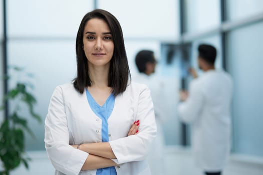 Image of confident female doctor, intern with medical robe, looking confident at camera
