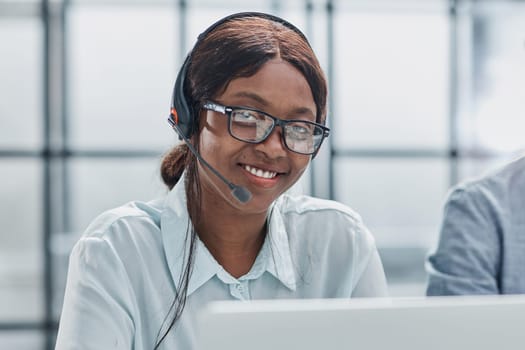 Call center agent with headset working on support hotline at modern office