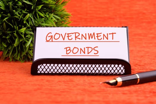 Government Bonds text on a white card on a stand on an orange background