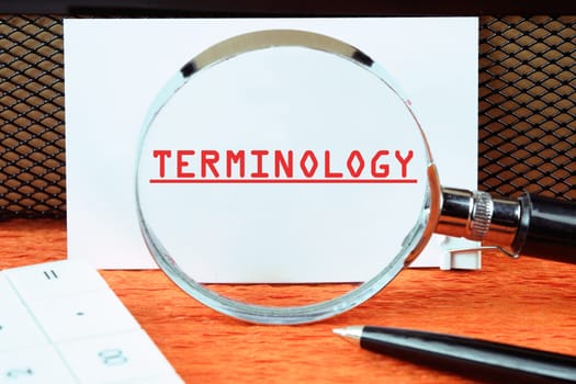 TERMINOLOGY text written on a white card through a magnifying glass