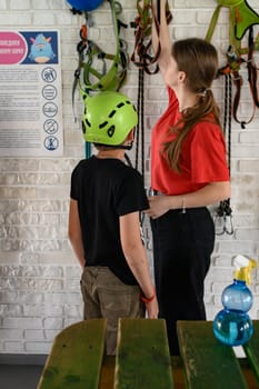 Ivano-Frankivsk, Ukraine June 7, 2023:A boy puts on a helmet and insurance before going on a cableway ride, a large playroom and a cable car in it.