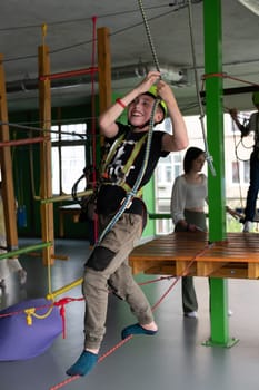 The boy is actively and attentively going through the cableway in the playroom, adrenaline and activity for children. Ivano-Frankivsk, Ukraine June 7, 2023