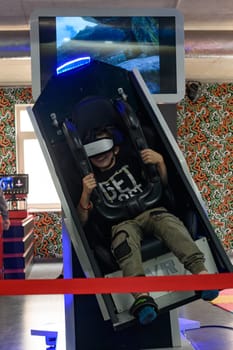 Ivano-Frankivsk, Ukraine June 7, 2023:A guy is sitting on a ride with vr glasses, 5d and adrenaline from virtual reality.