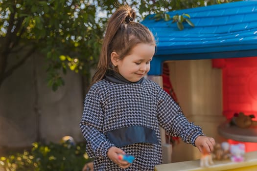 portrait of a little girl playing outdoors near her house