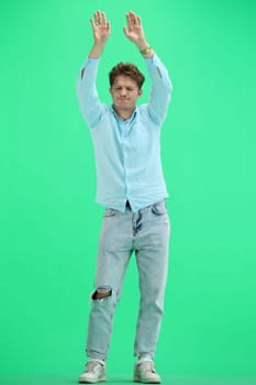 A man, on a green background, in full height, dancing.