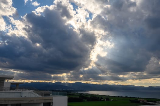 sun rays through dramatic clouds over mountains and sea in cyprus 1