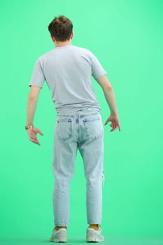 A man, full-length, on a green background.
