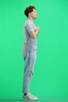 A man, full-length, on a green background.