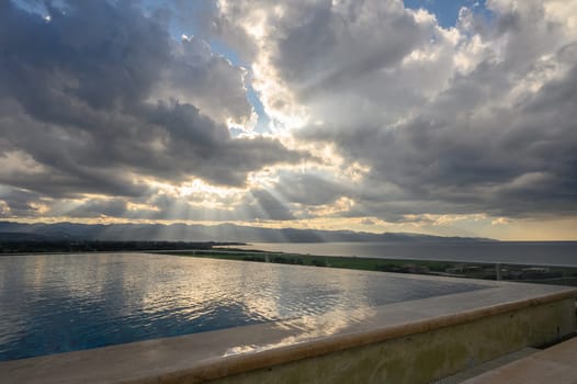 clouds and sun rays over the Mediterranean sea and mountains in winter in Cyprus