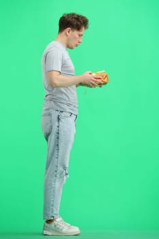 A man, full-length, on a green background, with a gift.
