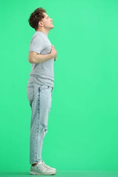 A man, full-length, on a green background.