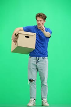 The deliveryman, in full height, on a green background, with a box, shows a stop sign.